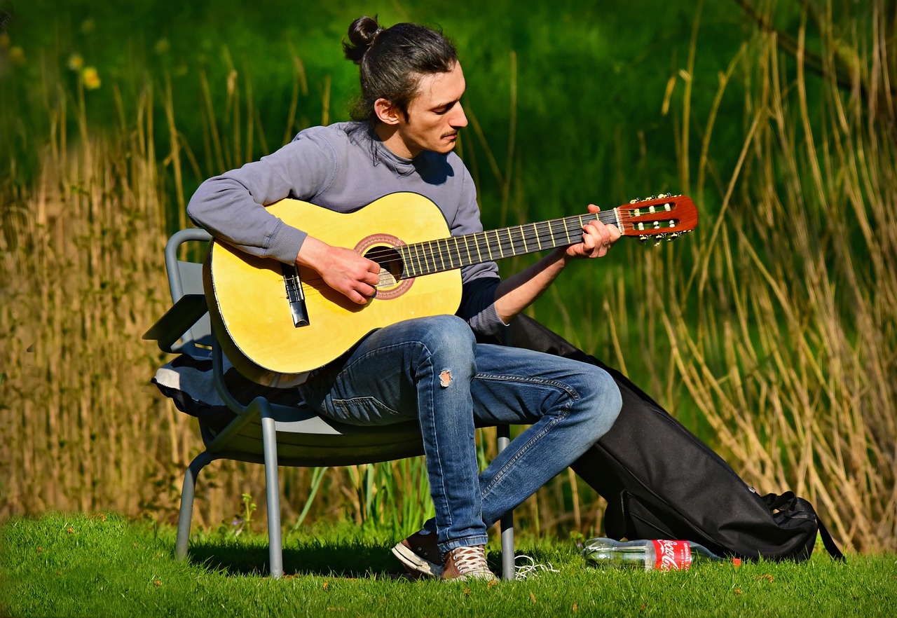 Сыграть на гитаре в траве. Человек с гитарой. Мужчина с гитарой. Гитарист на природе. Музыкант с гитарой.